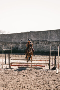 Horsewoman riding and jumping outdoors