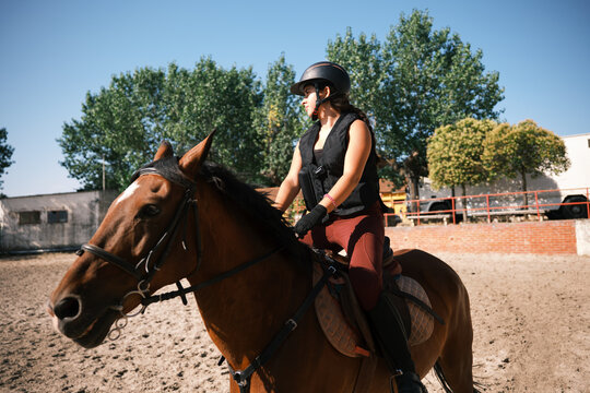 Cheerful horsewoman riding outdoors