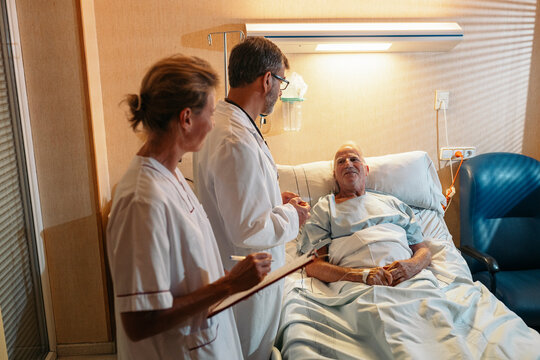 Medical team checking on senior patient recovering in hospital