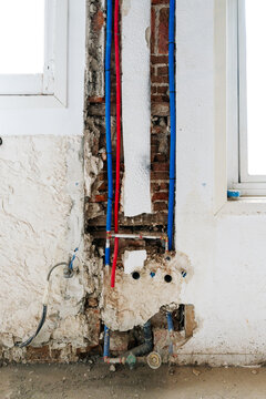 Exposed plumbing pipes on brick wall