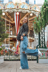Happy young woman posing near vintage carousel lights © Mila