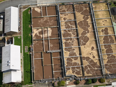Lilydale, Victoria, Australia - 10 September 2026: Aerial view of the Lilydale Wastewater Treatment Plant showing large aeration tanks with bubbling brown water and industrial infrastructure.