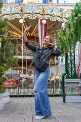 Happy young woman taking selfie near vintage carousel © Mila