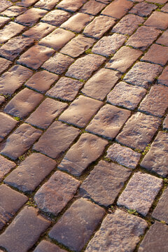 Old cobblestone pavement texture in golden hour light