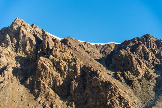 Rugged rocky ridge leading to Yukhin Peak under clear blue sky, Kyrgyzstan