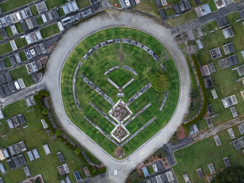 Ferntree Gully, Australia - 09 September 2026: Aerial view of Ferntree Gully Cemetery showing its unique circular layout, rows of headstones, green lawns, and burial plots.