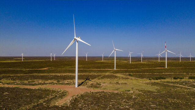Hopefield, South Africa - 08 September 2026: Aerial view of wind turbines in a vast field under a clear blue sky.