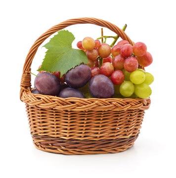Fresh grapes and plums in a wicker basket isolated on a white background.