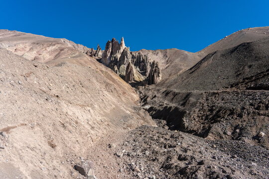 Jagged spire rock formation in the Kyrgyz Pamir mountains under clear blue sky