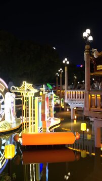 SHANGHAI, CHINA - AUGUST 23, 2026: Illuminated clock lantern art glows on the pond as tourists cross the bridge by Huxinting Pavilion at night in SHANGHAI China, in vertical timelapse