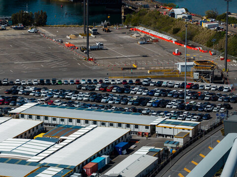 Rozelle, New South Wales, Australia - 07 September 2026: Aerial view of a vehicle storage yard and port logistics compound with parked cars, temporary buildings, and industrial infrastructure.