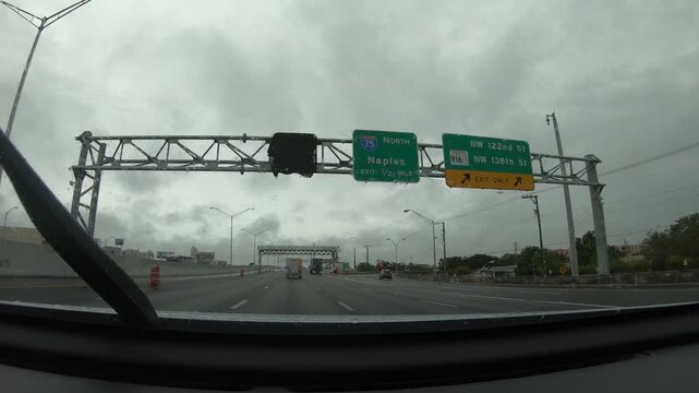 Driving POV on a Florida highway toward Naples during rain, showing wet pavement, moving traffic and the atmosphere of a rainy road trip through southern Florida.