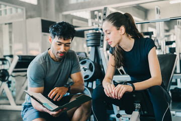 Professional personal trainer man and woman focused gym fitness exercising health care in gym...