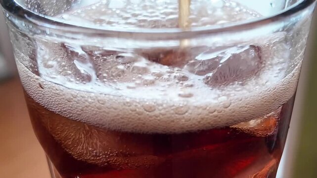 Cola Pouring Into Glass with Ice Macro Close Up