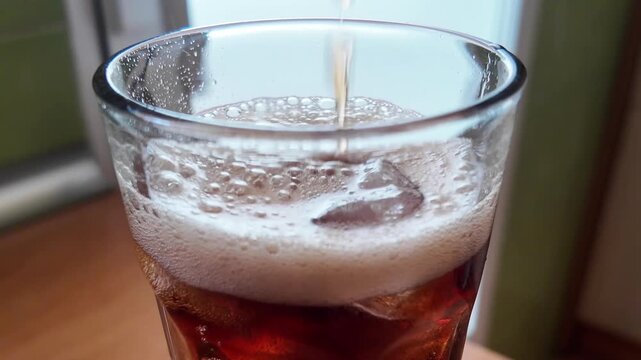 Cola Pouring Into Glass with Ice Close Up