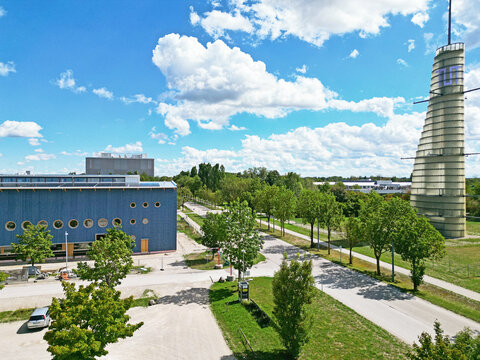 Garching bei Munchen, Germany - 29 August 2026: Aerial view of the Technical University of Munich meteorological tower at the campus entrance, with green trees and a modern blue building.
