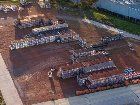 Melbourne, VIC, Australia - 07 September 2026: Aerial view of a tile manufacturing factory in Mitcham with stacks of ceramic tiles on an industrial lot at golden hour.