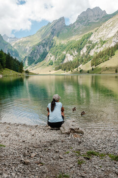 Relaxing by a serene lake surrounded by mountains in Seealpsee, Appenzell Switzerland