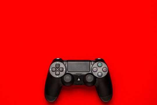 September 10, 2026, Odessa, Ukraine. Black Sony PS4 DualShock controller on bright red back