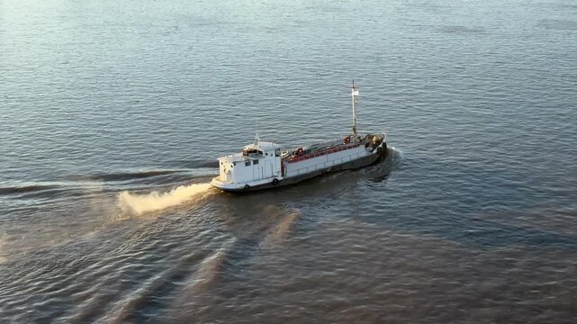small boat with smock proceeding by river.