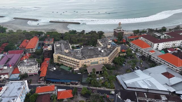 Aerial photo of Seminyak, Bali showing beachfront hotels, coastal road, sandy beach and rolling ocean waves; captures tropical resort atmosphere, travel lifestyle and coastal urban landscape