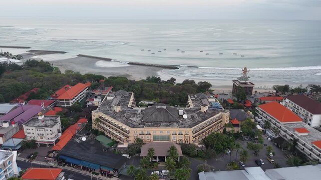 Aerial panorama of a beachfront hotel and resort district in Seminyak, Bali, with calm ocean, breakwaters and coastal streets at dawn conveying travel, tropical vacation and seaside relaxation
