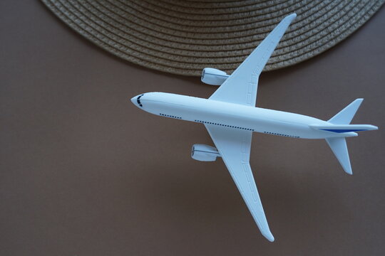 A plane next a straw hat on a brown background