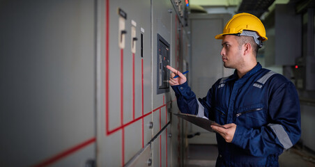 Obraz premium Electrical engineers and technicians work together to solve electrical system failures in industrial control rooms.supervisor maintains the circuit cabinet.