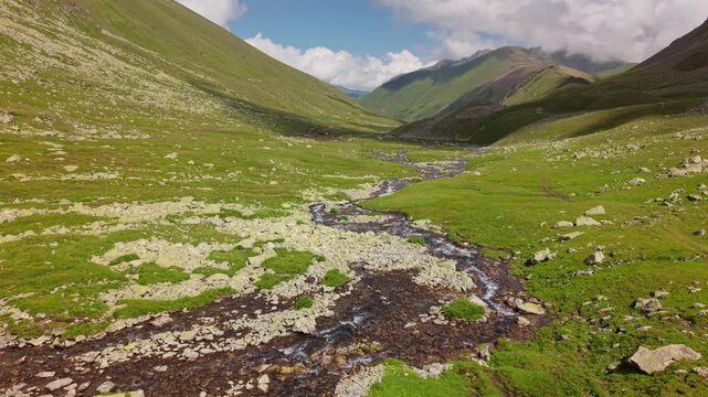 Aerial view of a winding river in a green mountain valley