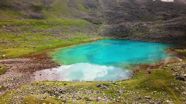 Aerial view of turquoise alpine lake in rocky basin