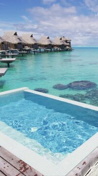 Resort hotel Infinity pool in travel vacation paradise with overwater bungalow in ocean lagoon with coral reef sea. 4K Video from Bora Bora, French Polynesia, Tahiti, South Pacific Ocean. Real video.