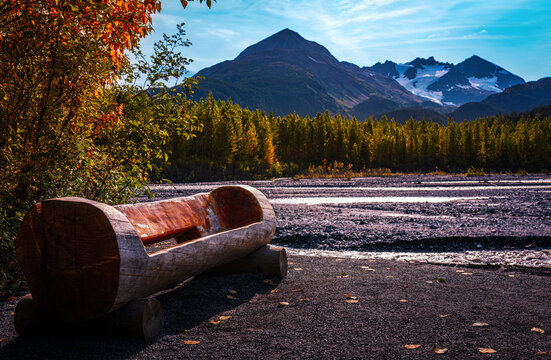 Empty wooden bench and Resurrection River valley autumn landscape at Exit Glacier in Kenai Fjords National Park in Seward, Alaska, USA