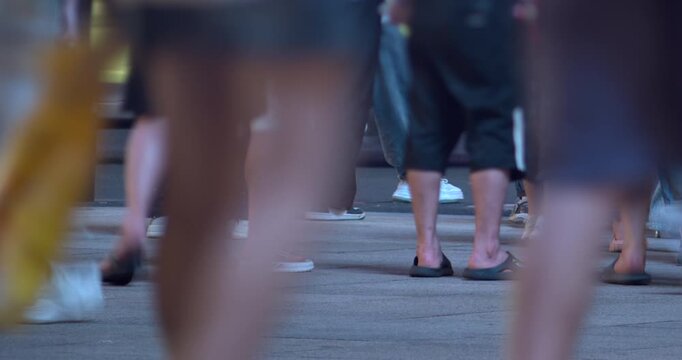 SHANGHAI, CHINA - AUGUST 23, 2026: Feet and legs of pedestrians walk along a busy pavement and street crossing in SHANGHAI CHINA, in timelapse