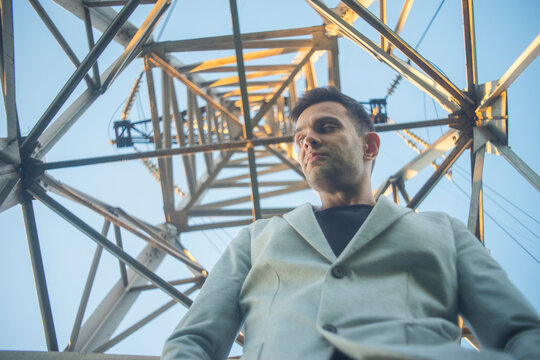 Corporate leader controlling complex power grid standing inside electricity tower with copy space