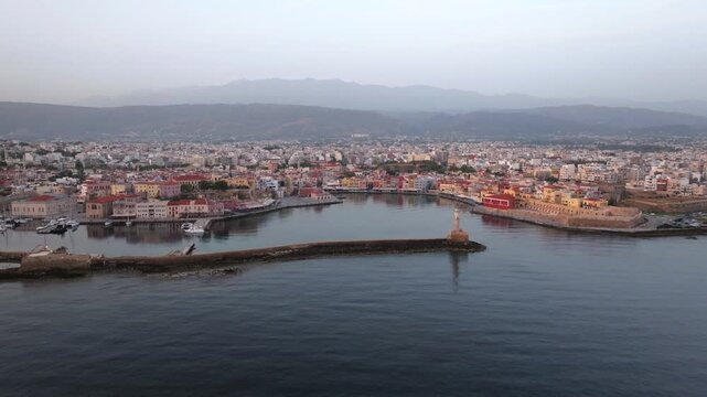  View of Chania with the amazing lighthouse, mosque, venetian shipyards, Crete, Greece.Waves crashing on lighthouse, Beautiful Greece and best scenic places - panorama
