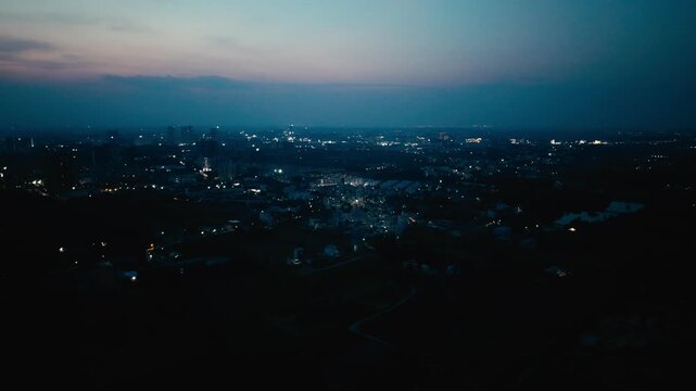 A serene top-down aerial perspective capturing a narrow, meandering river or swamp channel flowing through a vibrant, dense green ecosystem of trees, plants, and natural marshes in Bengaluru.