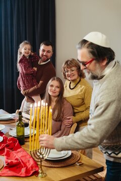 Jewish family celebrating hanukkah lighting menorah candles