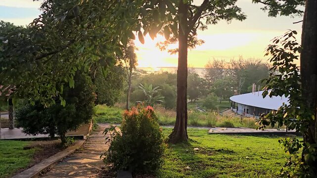 Scenic sunrise view in a lush green park with trees and pathway
