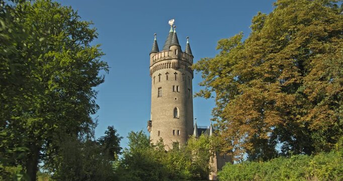Gothic Revival architecture and slate-roofed turrets distinguish Flatow Tower in Babelsberg Park, Potsdam, Germany.
