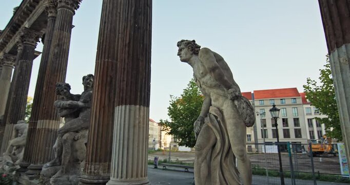 Stone sculpture beside a fluted column at Ringerkolonnade, Potsdam, Germany, showing weathered carved details.