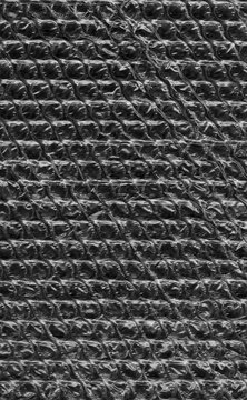 Black bubble wrap texture fills the frame as a repeating pattern with protective cushioning and packaging material