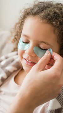 Closeup child wearing cooling under eye patches for allergy relief and soothing skincare at home for family wellness and pediatric healthcare design