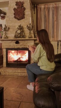 Woman relaxing by fireplace enjoying warm atmosphere