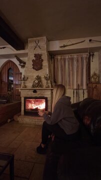 Woman relaxing by fireplace enjoying warmth and comfort