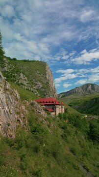 Aerial view of historic castle showcasing traditional architecture nestled in a lush green mountain valley