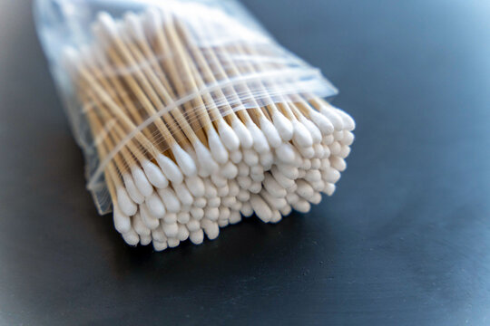 Cotton swabs packed in clear plastic on dark surface