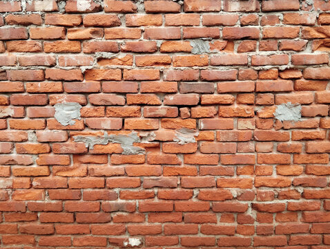 Weathered red brick wall texture with subtle erosion and moss growth for architectural or design projects