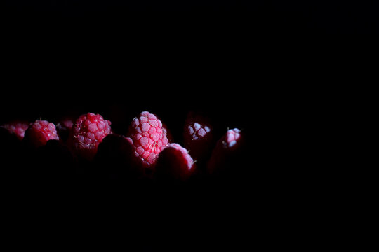 Frozen raspberries on dark background