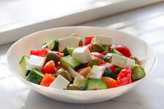 Greek salad with feta cheese and vegetables on a table