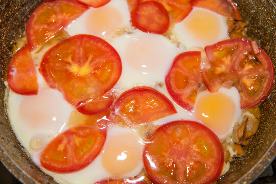 Eggs fried with tomatoes and onions.